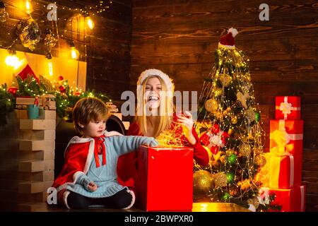 Weihnachten steht vor der Tür. Frau und der kleine Junge öffnen die Box mit Weihnachtslicht. Weihnachtsbaum schmücken. Dekorieren Sie Ihr Zuhause vor Weihnachten. Stockfoto