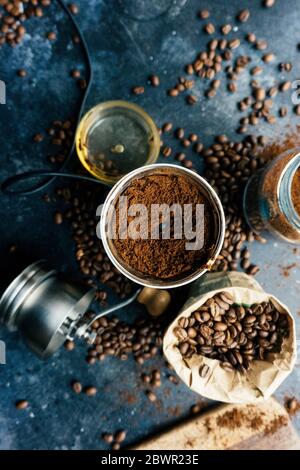 Kaffeebohnen in einer alten Kaffeemühle auf dunklem Hintergrund. Frisch gemahlener Kaffee und Bohnen vor der Zubereitung eines Getränks Stockfoto