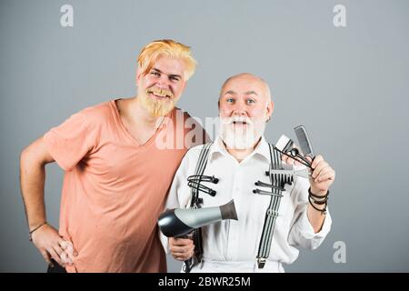 Mann Friseur mit Werkzeugen für Farbstoff, um die Haare Mann. Professioneller Friseur Herstellung stilvolle Mann Haarschnitt. Alt und jung. Stockfoto