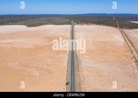 Luftaufnahmen der Straße über den trockenen rosa See auf dem Coolgardie-Esperance-Highyway nördlich von Norseman in Westaustralien Stockfoto