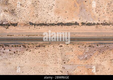 Luftaufnahme der Eisenbahnlinie auf dem trockenen rosa See auf dem Coolgardie-Esperance-Highyway nördlich von Norseman in Westaustralien Stockfoto