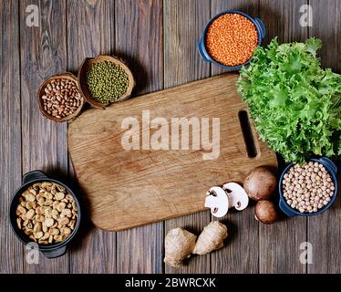 Sortiment aus Hülsenfrüchten, Linsen, Chikpea und Bohnen von oben. Zusammensetzung von verschiedenen Arten von Hülsenfrüchten in Schalen auf Holzhintergrund für eine gesunde Ernährung. Stockfoto