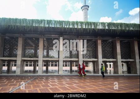 Jakarta, Indonesien. Juni 2020. Feuerwehrleute tragen Schutzanzüge und sprühen Desinfektionsmittel im Komplex der Istiqlal Moschee in Jakarta, Indonesien, 3. Juni 2020. Kredit: Agung Kuncahya B./Xinhua/Alamy Live News Stockfoto