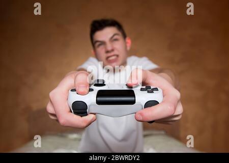 Der junge Kerl ist leidenschaftlich über Computerspiel. Selektiver Fokus auf einen Joystick Stockfoto