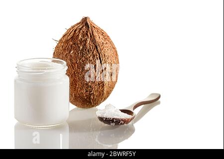 Zusammensetzung mit Kokosnuss, Holzlöffel und Gläser Kokosbutter. Das Konzept der gesunden Ernährung. Stockfoto