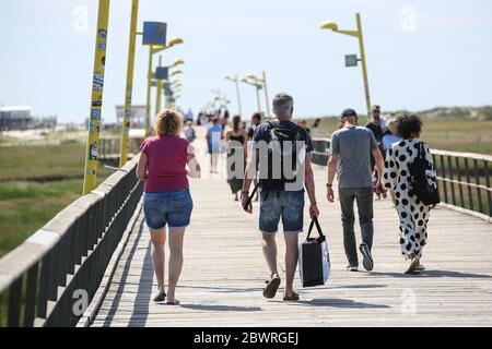 St. Peter Ording, Deutschland. Juni 2020. Urlauber sind auf der Anlegestelle in Sankt Peter-Ording. Der Pier verbindet einen Strandabschnitt mit der Promenade und ist gut einen Kilometer lang. St. Peter-Ording wurde wegen der Koronakrise über Pfingsten einem Verbot von Tagesbesuchern ausgesetzt. Kredit: Bodo Marks/dpa/Alamy Live News Stockfoto