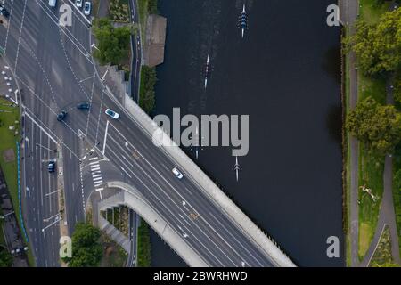 Luftaufnahme von unkenntlich identifizierbaren Rudern auf dem Yarra River und Autos auf der Swan Street Bridge in Melbourne, Australien Stockfoto