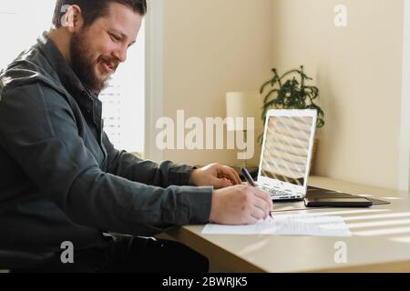 Geschäftsmann Schreiben von Rücktritt und mit Laptop. Stockfoto