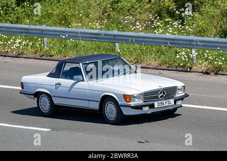 1987 80s Achtziger weißer Mercedes Benz 5600 cm3 Benzinkabriolet; Fahrzeuge für den Fahrzeugverkehr, Cabriolet, Cabriolet, Faltverdeck, offenes Dach, 80s Roadster, Cabriolets, Drop-Top-Autos, die Fahrzeuge auf britischen Straßen fahren, Motoren, Autos auf der Autobahn M6 Stockfoto