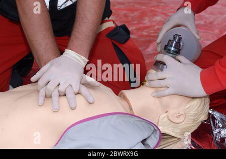 Nothelfer drückt auf die Brust eines Patienten und hält ein Sauerstoffkissen auf seinem Gesicht. Künstliche Beatmung Stockfoto