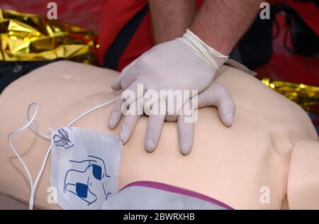 Nothelfer drückt auf die Brust eines Patienten und hält ein Sauerstoffkissen auf seinem Gesicht. Künstliche Beatmung Stockfoto