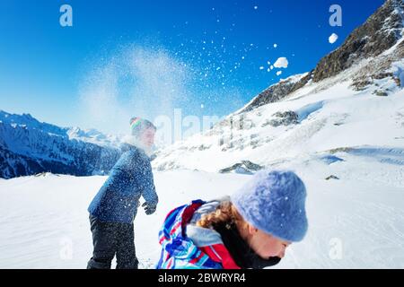 Spaß mit Schneeball Mädchen wirft auf einen anderen Schnee Ply Action Winter Spiel in den Bergen Stockfoto