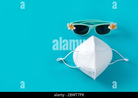 Sonnenbrille und Schutzmaske auf blauem Hintergrund Stockfoto