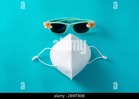 Sonnenbrille und Schutzmaske auf blauem Hintergrund Stockfoto