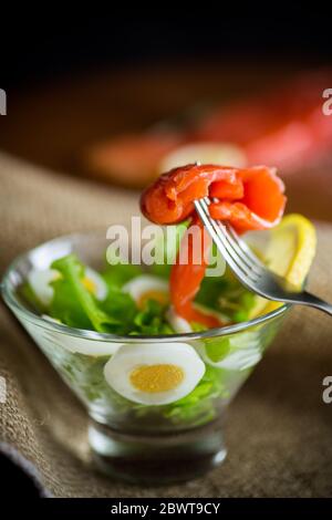 Salat mit gesalzenem Lachs, gekochten Eiern Stockfoto