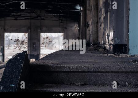 Nahaufnahme der letzten Stufe einer Steintreppe und eines leeren Flurs eines alten großen verlassenen Gebäudes Stockfoto