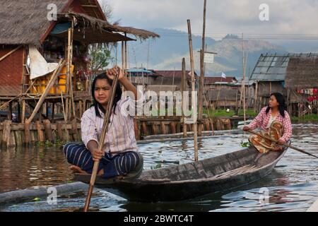 Junge Burmesen rudern auf einem Boot, Inle Lake, Myanmar Stockfoto