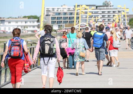 St. Peter Ording, Deutschland. Juni 2020. Urlauber sind auf der Anlegestelle in Sankt Peter Ording. Der Pier verbindet einen Strandabschnitt mit der Promenade und ist gut einen Kilometer lang. St. Peter-Ording wurde wegen der Koronakrise über Pfingsten einem Verbot von Tagesbesuchern ausgesetzt. Kredit: Bodo Marks/dpa/Bodo Marks/dpa/Alamy Live News Stockfoto