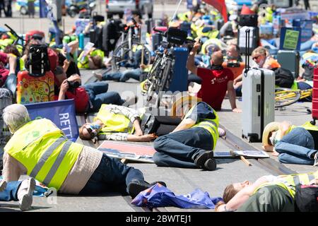 Dresden, Deutschland. Juni 2020. Die Teilnehmer einer Demonstration unter dem Motto "Tourismus am Rande der Ohnmacht" liegen bei einer Kundgebung auf der Straße. Mit der Demonstration wollen die Reiseveranstalter und Busunternehmen auf die schwierige aktuelle Situation der Tourismusbranche hinweisen. Quelle: Sebastian Kahnert/dpa-Zentralbild/dpa/Alamy Live News Stockfoto