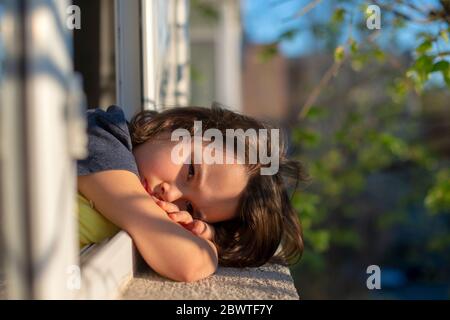 Nahaufnahme von Porträt aufgeregt kleines Mädchen schauen weit im Fenster denken über Probleme, trauriges Kind. Stockfoto