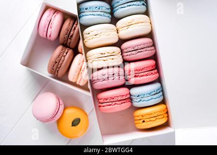 Bunte Makronen auf Holztisch. Süßen Macarons in Geschenkbox. flache Lay mit textfreiraum für Ihren text Stockfoto