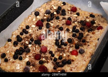 Vegetarische Früchte ungebackene Pizzateig mit Beeren und Mandeln. Frische Pizza in einer Kasserolle in der Küche. Vegetarisches Essen Konzept Stockfoto