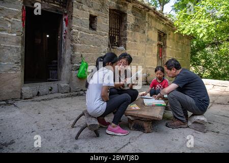 (200603) -- LINGCHUAN, 3. Juni 2020 (Xinhua) -- die chinesische Lehrerin Cui Lianrui (2. L) und der Rektor Zhao Jincheng helfen Schülern beim Studium im Dorf Nanbei im Landkreis Lingchuan, in der nordchinesischen Provinz Shanxi, am 31. Mai 2020. Am 2. Juni kehrten Qin Chunlan, Qin Qiulan und Qin Xingwang in die Schule zurück. Früh am Morgen stiegen sie auf das Dreirad ihres Vaters und eilten zur Grundschule des Mawuzhai Internat, das mehr als 10 Kilometer entfernt ist. Die Familie der drei Kinder ist der einzige Haushalt im Dorf Nanbei im Landkreis Lingchuan, und die Grundschule ist die einzige Schule innerhalb einer Stockfoto