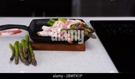 Frischer Spargel in Bacon eingewickelt bereit zum Grillen auf Eiserne Pfanne.. Stockfoto