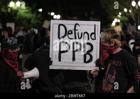 Portland, USA. Juni 2020. Protestler halten ein Schild, das fordert, dass das Portland Police Bureau in der fünften Nacht der Aktion gegen Polizeibrutalität in Portland, Oregon, am 2. Juni 2020 nach dem Tod von George Floyd in Polizeigewahrsam definanziert wird. (Foto: Alex Milan Tracy/Sipa USA) Quelle: SIPA USA/Alamy Live News Stockfoto