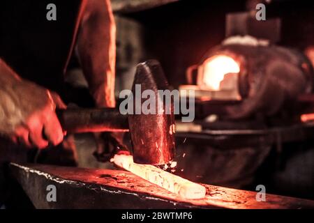 Messermacher bei der Arbeit, Stahlsplitter beim Hämmern Damast Stahl Stockfoto