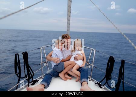 Vater mit seinen Kindern auf dem Bootsdeck während der Segeltörn sitzen Stockfoto