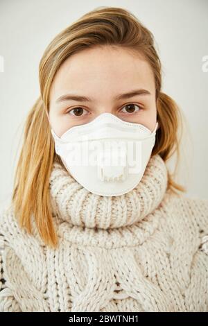 Portrait der blonden Frau trägt FFP2 Maske zu Hause Stockfoto