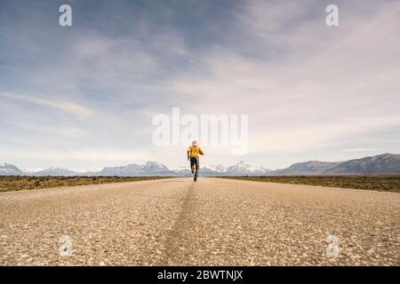 Mann, der auf einer Straße in einer abgelegenen Landschaft in Patagonien, Argentinien, läuft Stockfoto