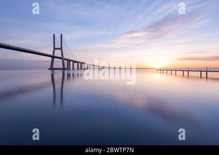 Portugal, Lissabon, Vasco da Gama Brücke bei stimmungsvollen Sonnenaufgang Stockfoto
