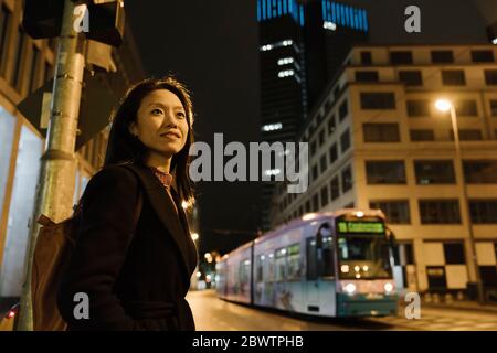 Junge Frau in der Stadt bei Nacht, Frankfurt, Deutschland Stockfoto