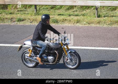 Triumph Thruxton Motorrad-Fahrer; zwei Radtransporte, Motorräder, Fahrzeug, Straßen, Motorräder, Motorradfahrer fahren auf der Autobahn M6 Chorley, Großbritannien Stockfoto