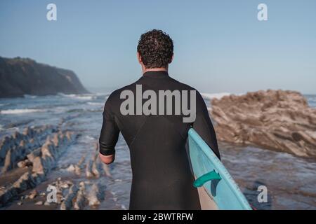 Behinderter Surfer mit Surfbrett am Strand Stockfoto