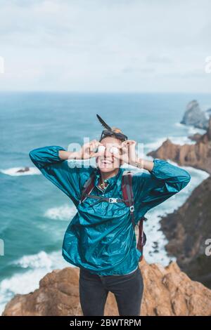 Portugal, Lissabon, Sintra, Portrait einer Wanderin, die lächelt und dabei vorgibt, Steine als Sonnenbrillen zu tragen Stockfoto