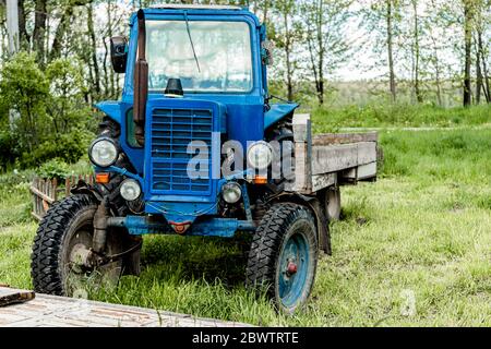 Blauer Traktor steht auf einer Straße in Russland Stockfoto