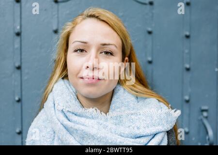 Portrait der blonden jungen Frau mit hellblauem Schal Stockfoto