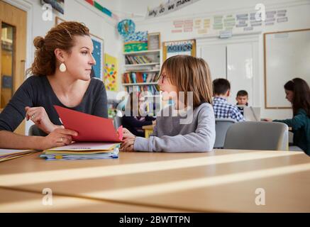 Junge mit dem Lehrer in einem Klassenzimmer diskutieren Stockfoto