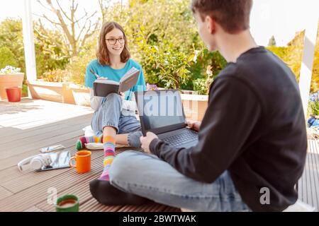 Teenager Mädchen lernen zusammen mit ihrem Freund auf der Terrasse Stockfoto