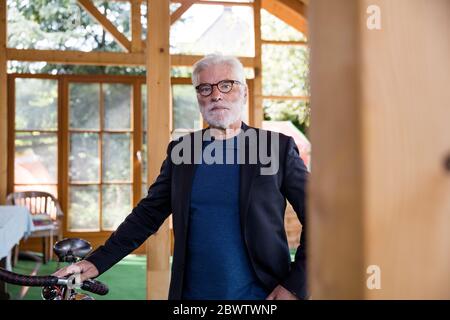 Porträt eines bärtigen älteren Mannes mit Rennrad in einem Tierheim Stockfoto