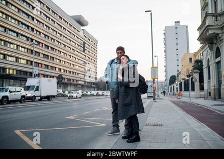 Junges Paar, das am Straßenrand in der Stadt, Mailand, Italien, steht Stockfoto