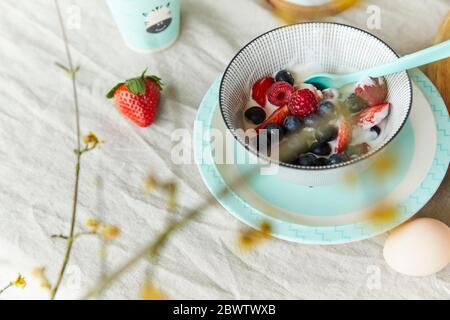 Schüssel mit Fruchtmüsli und Ei auf dem Frühstückstisch Stockfoto