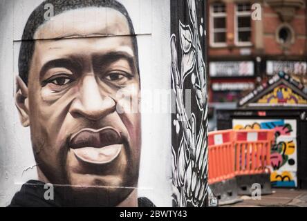 Juni 2020. Manchester, Vereinigtes Königreich. Menschenmengen versammeln sich auf dem Stevenson Square, als der französische Straßenkünstler AKSE p19 ein Wandgemälde von George Floyd vervollständigt. Das Wandgemälde markiert den Tod von Floyd, einem schwarzen Mann, nachdem er unter dem Knie eines weißen Polizisten in Minneapolis für fast neun Minuten festgeklemmt wurde. Quelle: Howard Harrison/Alamy Live News Stockfoto