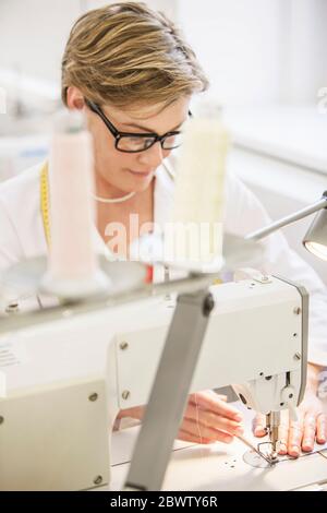 Kanalisation bei der Arbeit in einem Schneidergeschäft Stockfoto