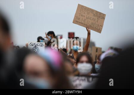 Eine Frau hält ein Schild während einer Protestkundgebung für Belly Mujinga (47) im Hyde Park, London, hoch, der im April starb, nachdem er während seiner Arbeit am Londoner Bahnhof Victoria angespuckt und hustet wurde. Stockfoto