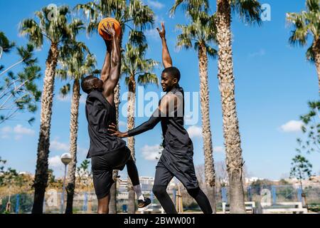 Basketballspieler spielen Basketball auf dem Platz im Freien Stockfoto