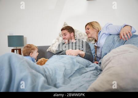 Familie spielen zusammen auf Bett Stockfoto